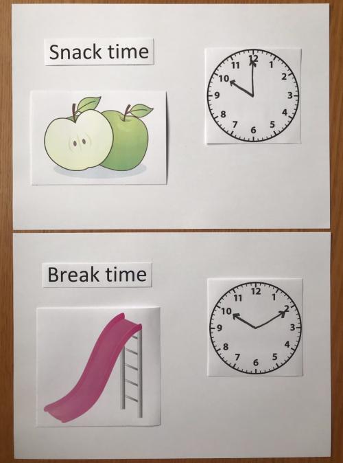 The top piece of paper shows 'Snack time', two apples and a clock at 10:00. The bottom piece of paper shows 'Break time', a slide and a clock at 10:10.