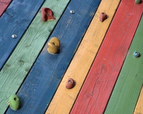 A colourful wooden climbing wall.