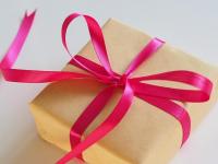 A present wrapped in brown paper, with a ribbon tied around it.