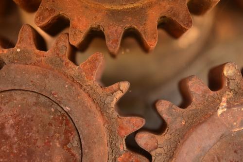 Three interlocking rusty gears.